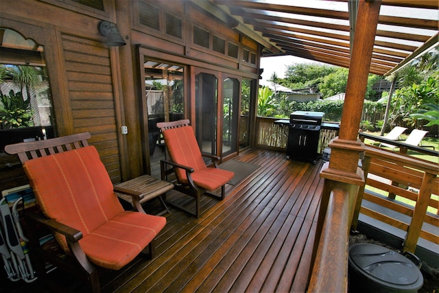 wooden deck with area for grilling and a pergola