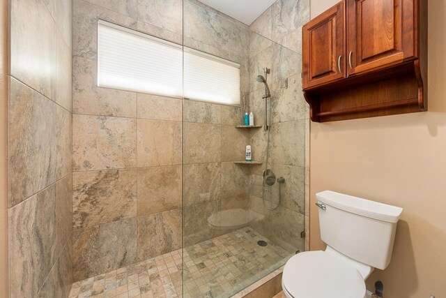 bathroom featuring toilet and tiled shower