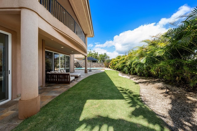 view of yard featuring a balcony and a patio