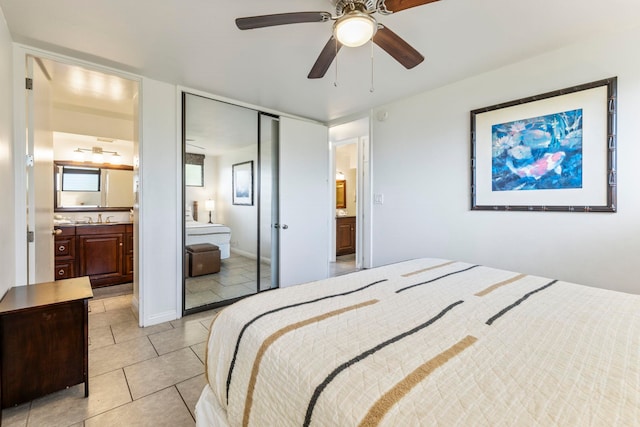 bedroom with ceiling fan, sink, ensuite bathroom, a closet, and light tile patterned floors