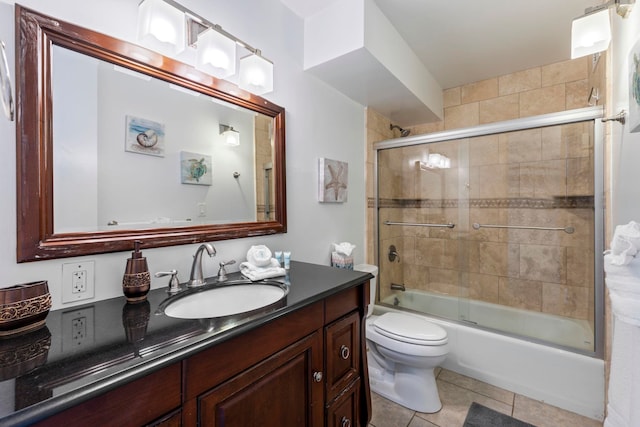 full bathroom featuring tile patterned floors, vanity, toilet, and bath / shower combo with glass door