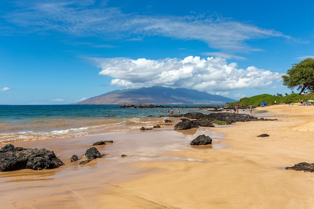 water view with a mountain view and a view of the beach