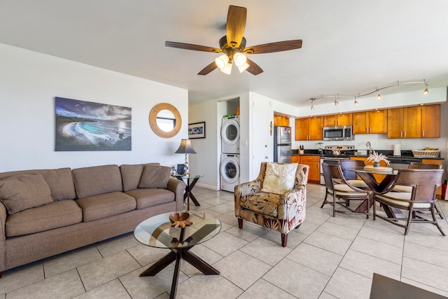 tiled living room with stacked washing maching and dryer and ceiling fan