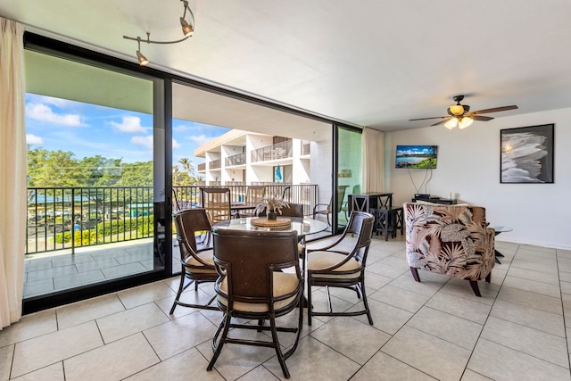 dining area featuring light tile patterned floors, expansive windows, and ceiling fan