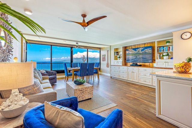 living room featuring floor to ceiling windows, ceiling fan, hardwood / wood-style floors, and built in features