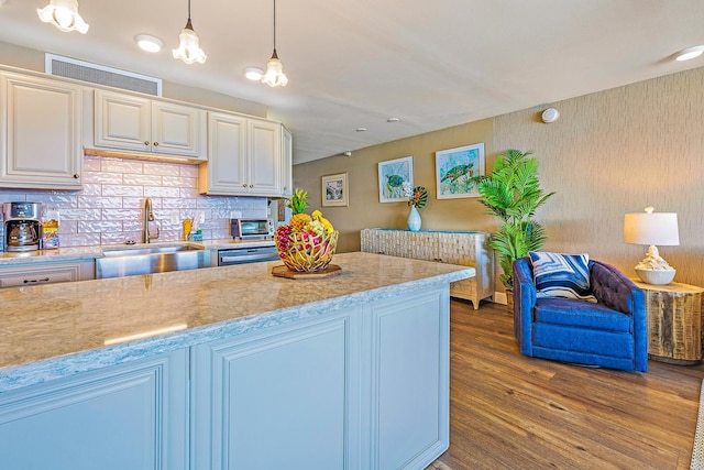 kitchen featuring dark hardwood / wood-style flooring, decorative light fixtures, backsplash, and sink