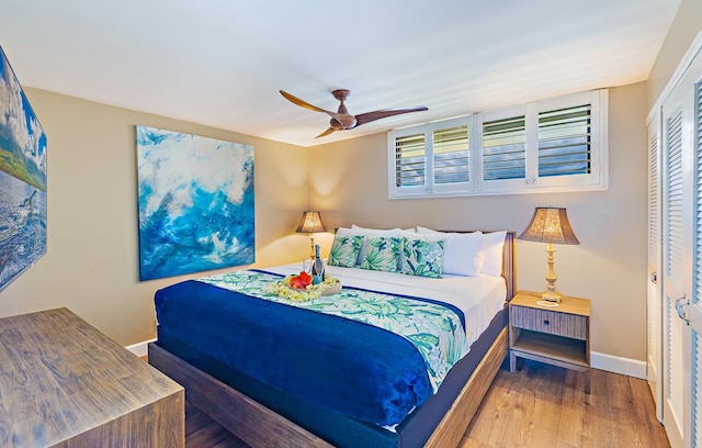 bedroom featuring hardwood / wood-style floors, ceiling fan, and a closet