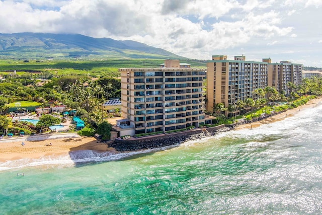 drone / aerial view featuring a view of the beach and a water and mountain view