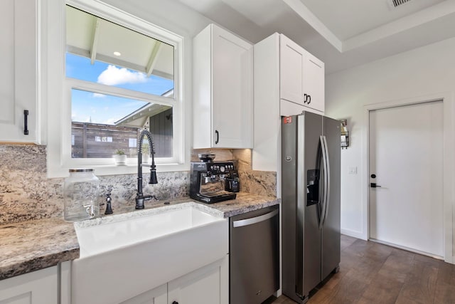 kitchen featuring sink, appliances with stainless steel finishes, tasteful backsplash, light stone countertops, and white cabinets