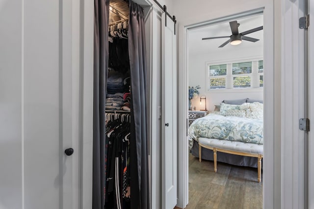 bedroom featuring a barn door and hardwood / wood-style floors