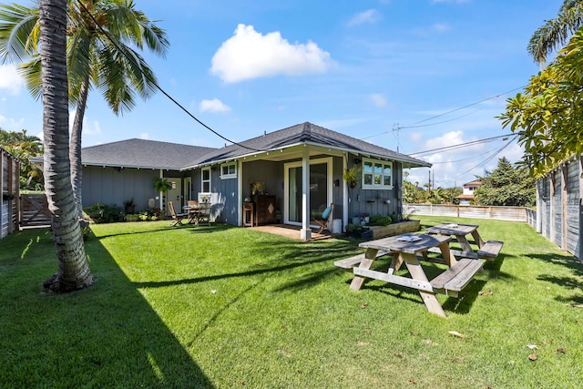 rear view of house featuring a yard