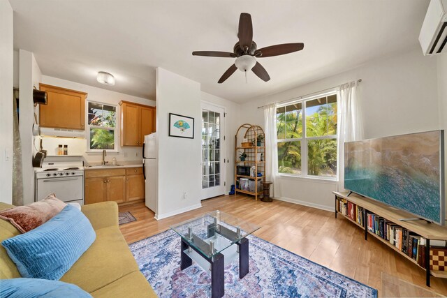 206 Kuli Puu St, Kihei, HI 96753 - living area featuring a wall mounted air conditioner, light wood-type flooring, a ceiling fan, and baseboards