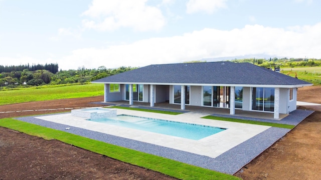 back of house featuring a swimming pool with hot tub and a patio