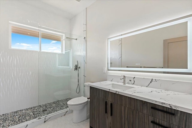 bathroom featuring vanity, toilet, and tiled shower