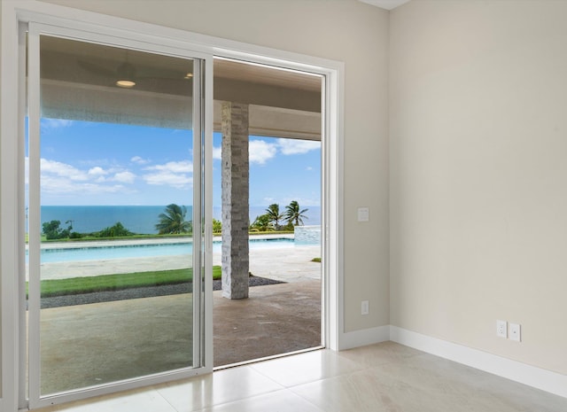 doorway with a water view and light tile patterned floors