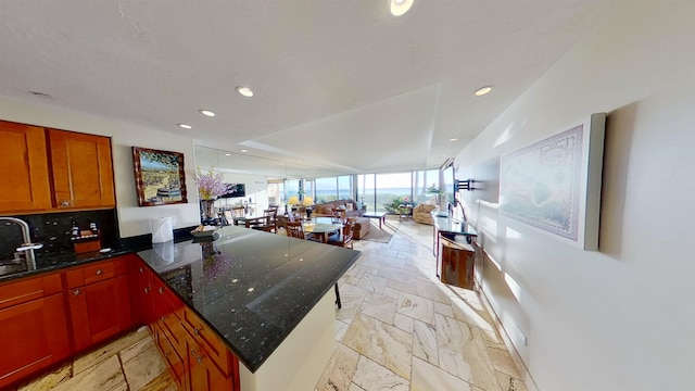 kitchen featuring tasteful backsplash, kitchen peninsula, and a wall of windows