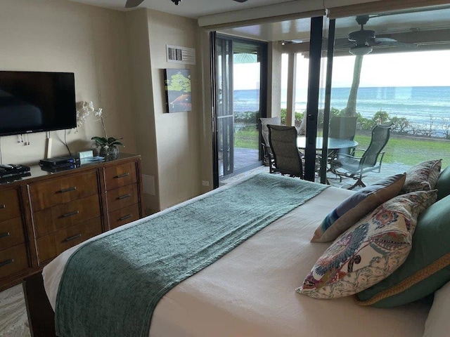 bedroom featuring access to exterior, ceiling fan, and a water view