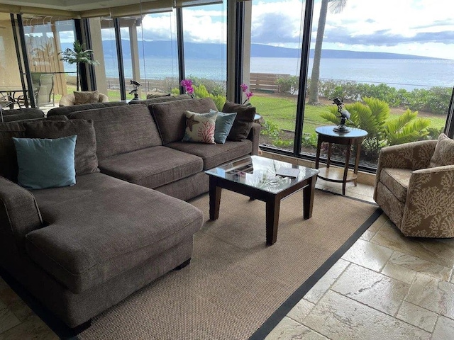 sunroom featuring a wealth of natural light and a water view