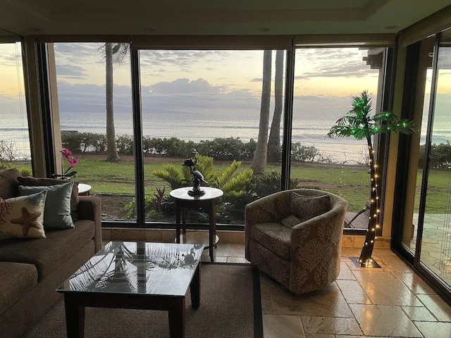 sunroom featuring a water view