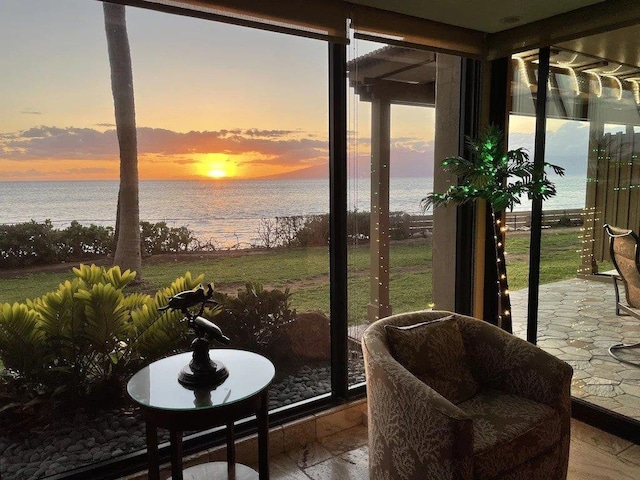 sunroom featuring a water view