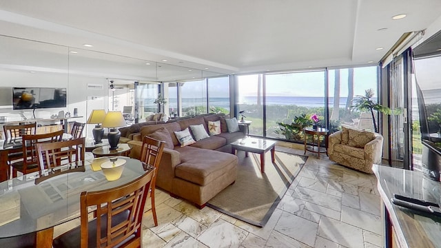 sunroom featuring a water view and ceiling fan