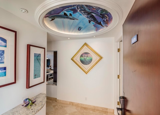 interior space featuring a tray ceiling and light tile floors