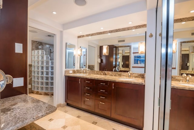 bathroom featuring tile floors, dual sinks, and vanity with extensive cabinet space