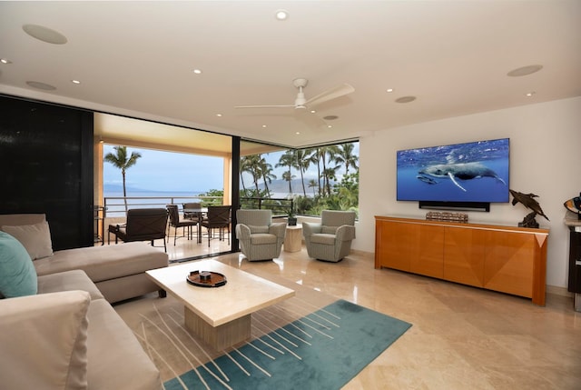 living room with ceiling fan, a water view, light tile floors, and expansive windows