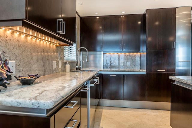 kitchen featuring light tile flooring, light stone countertops, backsplash, dark brown cabinetry, and sink