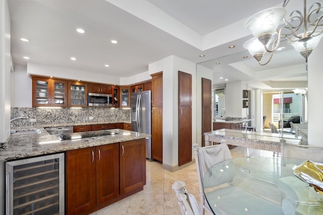 kitchen featuring beverage cooler, stainless steel appliances, light stone counters, and backsplash