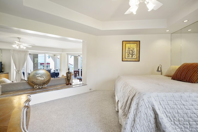 bedroom with a ceiling fan, a tray ceiling, carpet, and recessed lighting