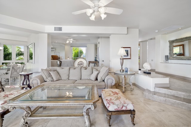 living area with tile patterned floors, a ceiling fan, visible vents, and baseboards