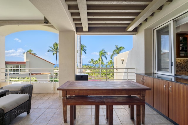 view of patio with a balcony and outdoor dining area