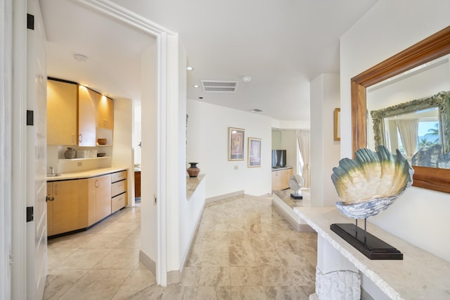 corridor with recessed lighting, visible vents, light tile patterned flooring, a sink, and baseboards