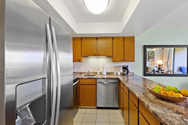 kitchen featuring sink, stainless steel appliances, a raised ceiling, and light tile patterned floors