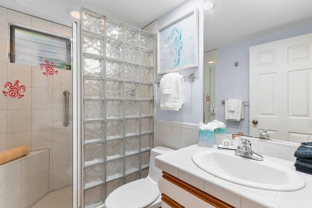 bathroom featuring toilet, vanity, and a shower with shower door