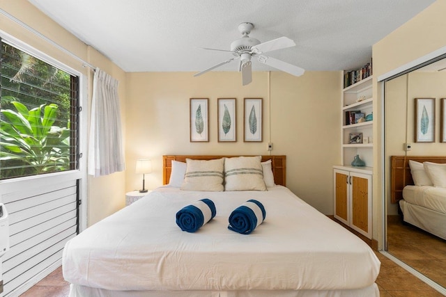 bedroom with a closet, tile patterned floors, a textured ceiling, and ceiling fan