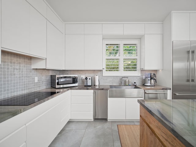 137 Hoohale St, Kihei, HI 96753 - kitchen with backsplash, light tile patterned floors, a sink, appliances with stainless steel finishes, and white cabinetry