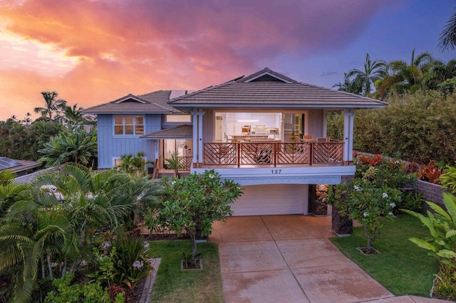 137 Hoohale St, Kihei, HI 96753 - view of front facade featuring a tiled roof, concrete driveway, an attached garage, a balcony, and a front yard