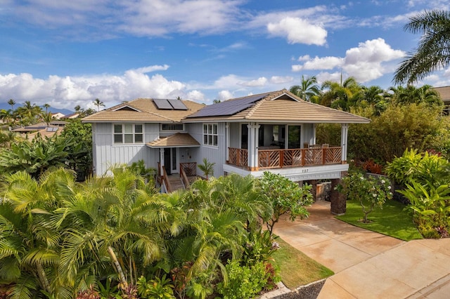 137 Hoohale St, Kihei, HI 96753 - view of front of home with a tiled roof, concrete driveway, board and batten siding, solar panels, and a carport