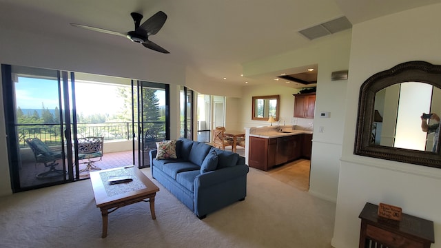 living room featuring light carpet, plenty of natural light, ceiling fan, and sink