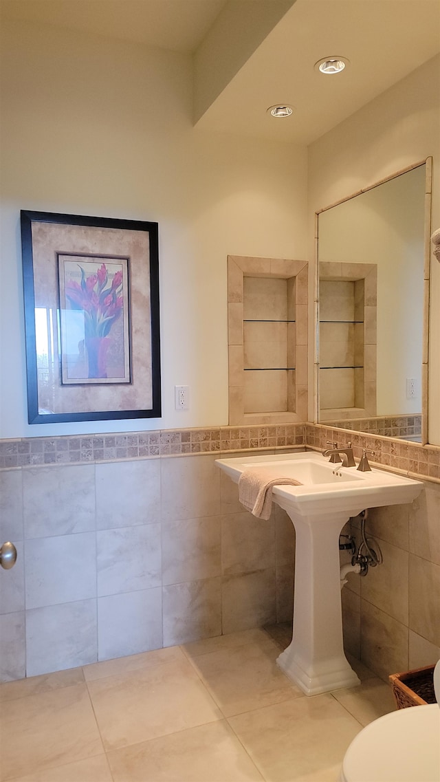 bathroom featuring tile patterned flooring, toilet, and tile walls