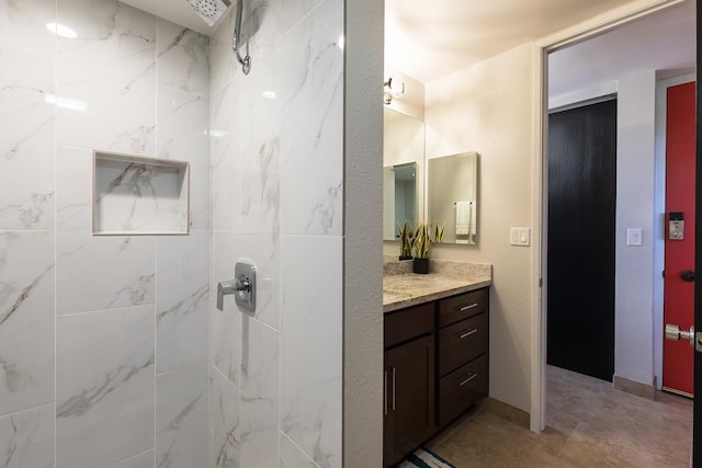 bathroom with vanity and a tile shower