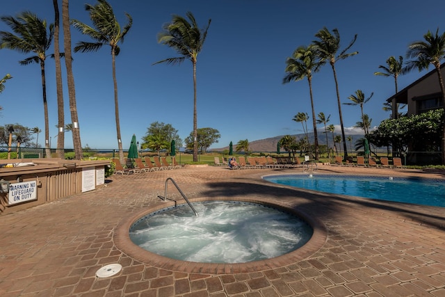 view of pool featuring a community hot tub and a patio