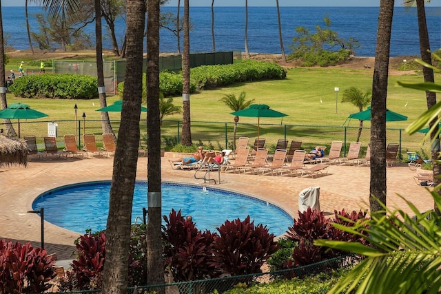 view of pool featuring a water view, a yard, and a patio