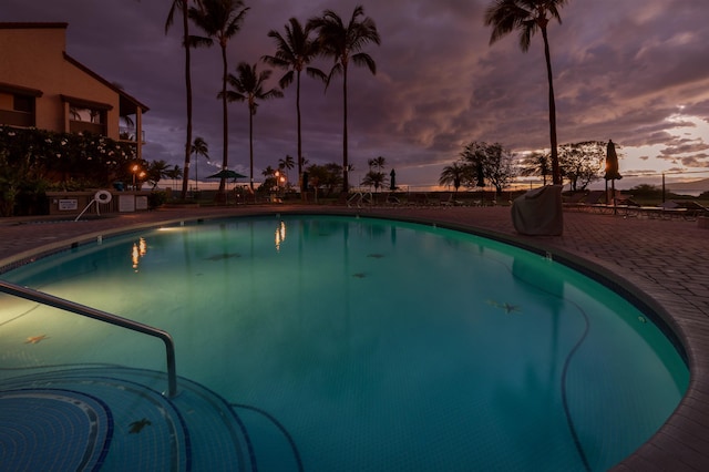 pool at dusk with a patio