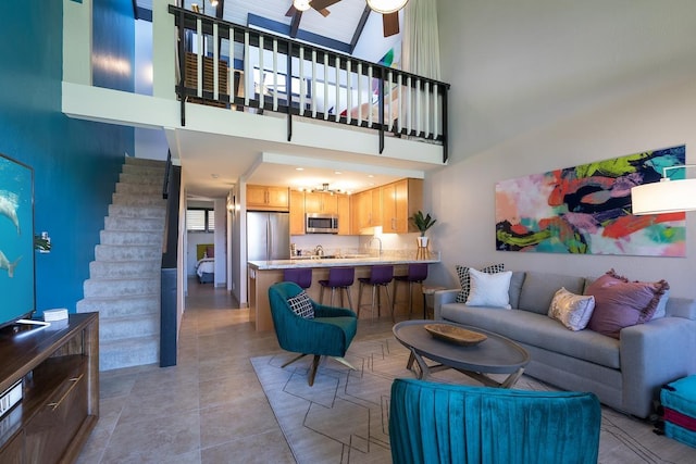 living room with a high ceiling, ceiling fan, and sink