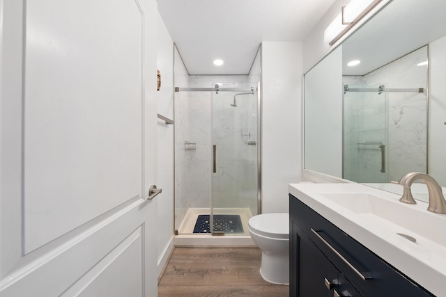 bathroom featuring vanity, toilet, hardwood / wood-style flooring, and walk in shower