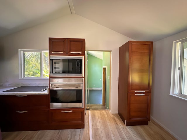 kitchen with vaulted ceiling, black microwave, light hardwood / wood-style flooring, electric cooktop, and oven