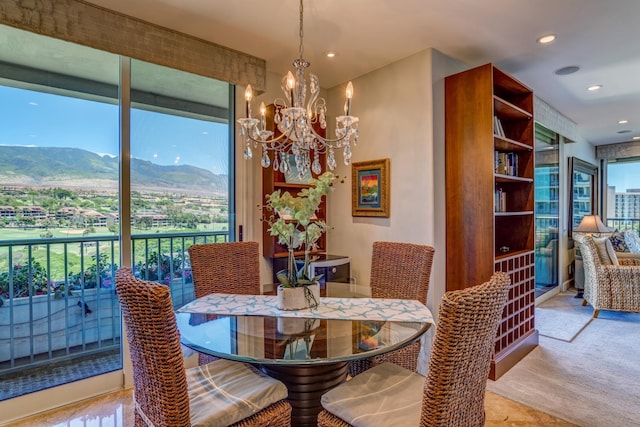carpeted dining room featuring a mountain view and a notable chandelier